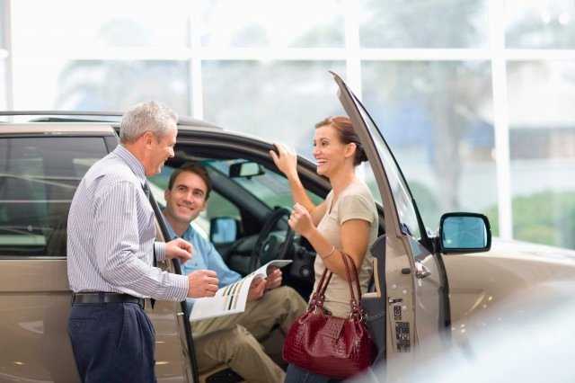 married couple looking at a consumer loans plan for their new car