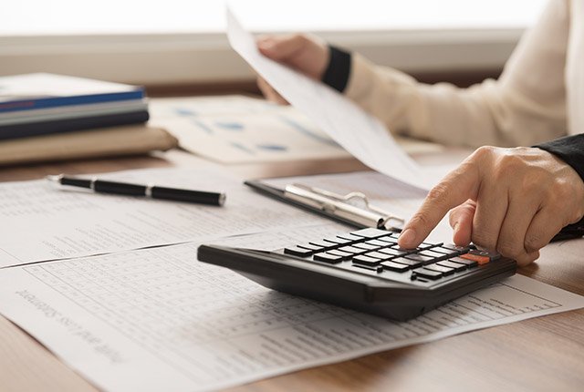 cpa firm employee working at his desk using a calculator